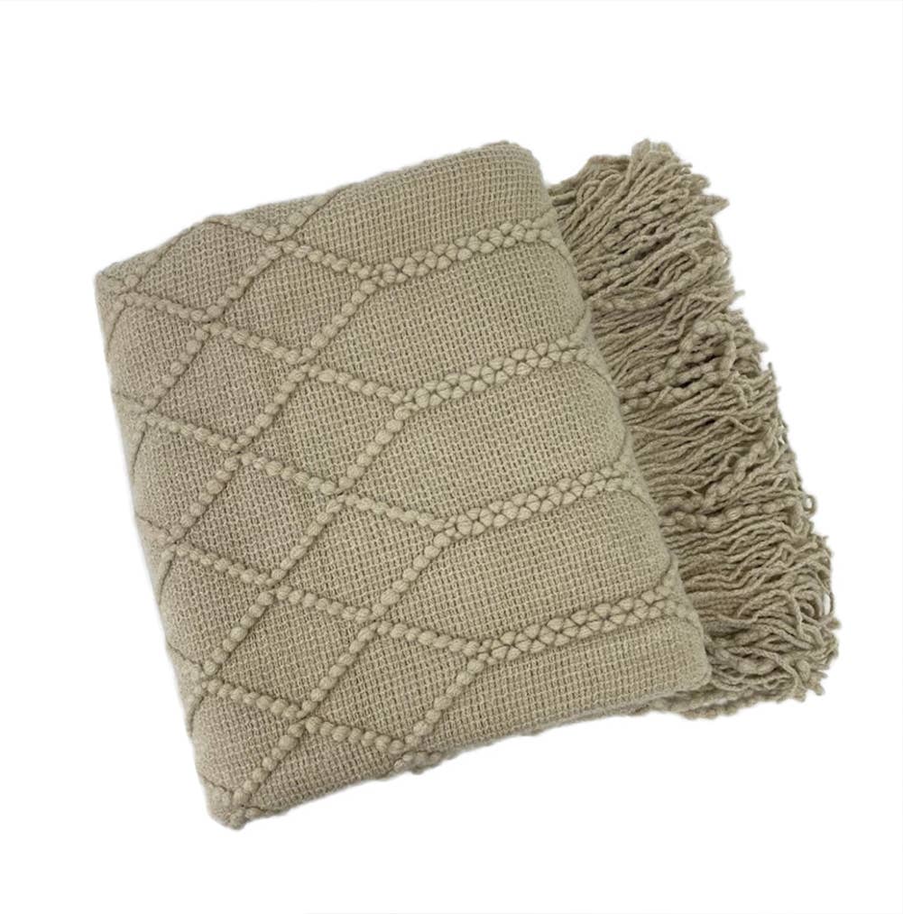 Textured beige blanket with diamond pattern and tassels on a white background