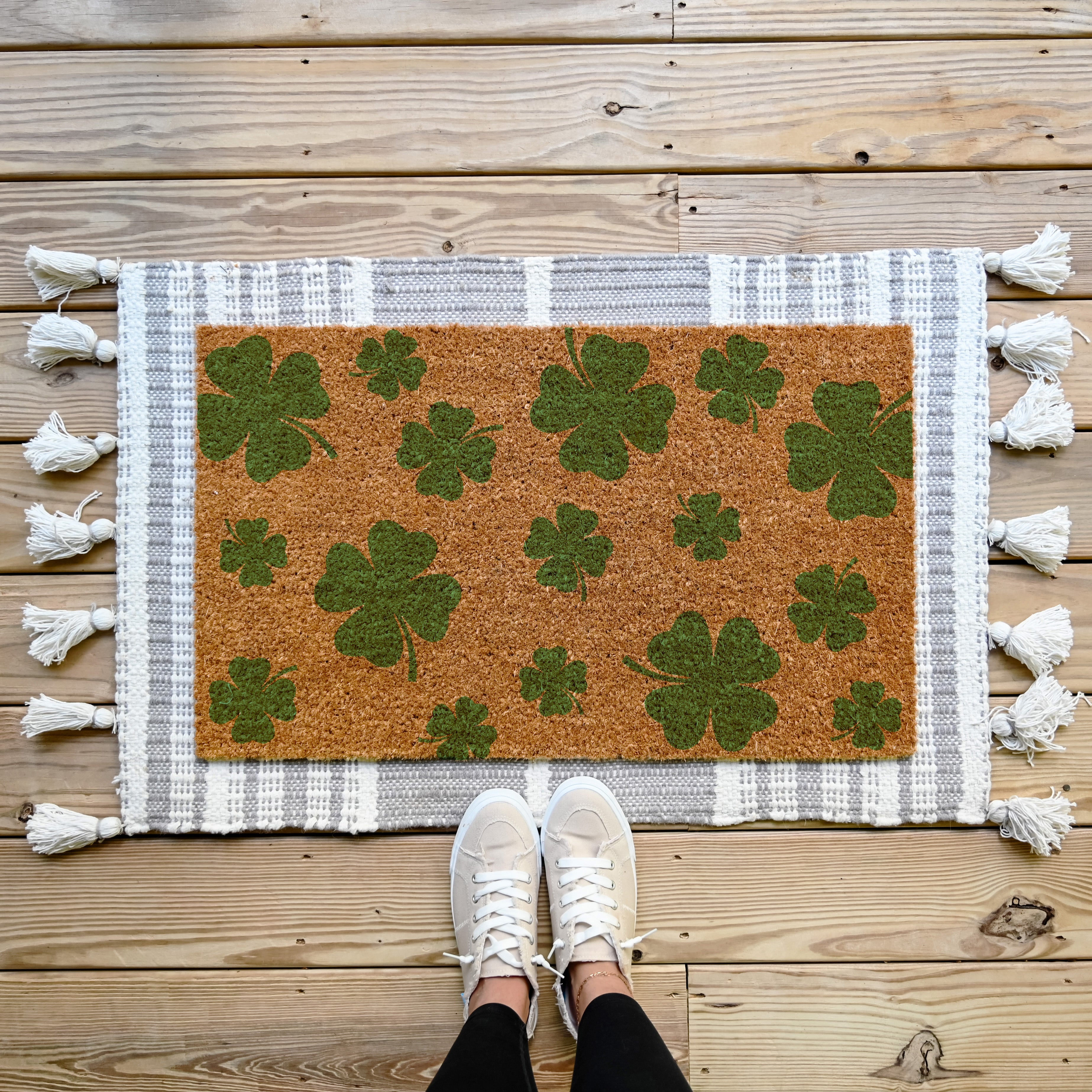 coir doormat with green shamrocks on it.