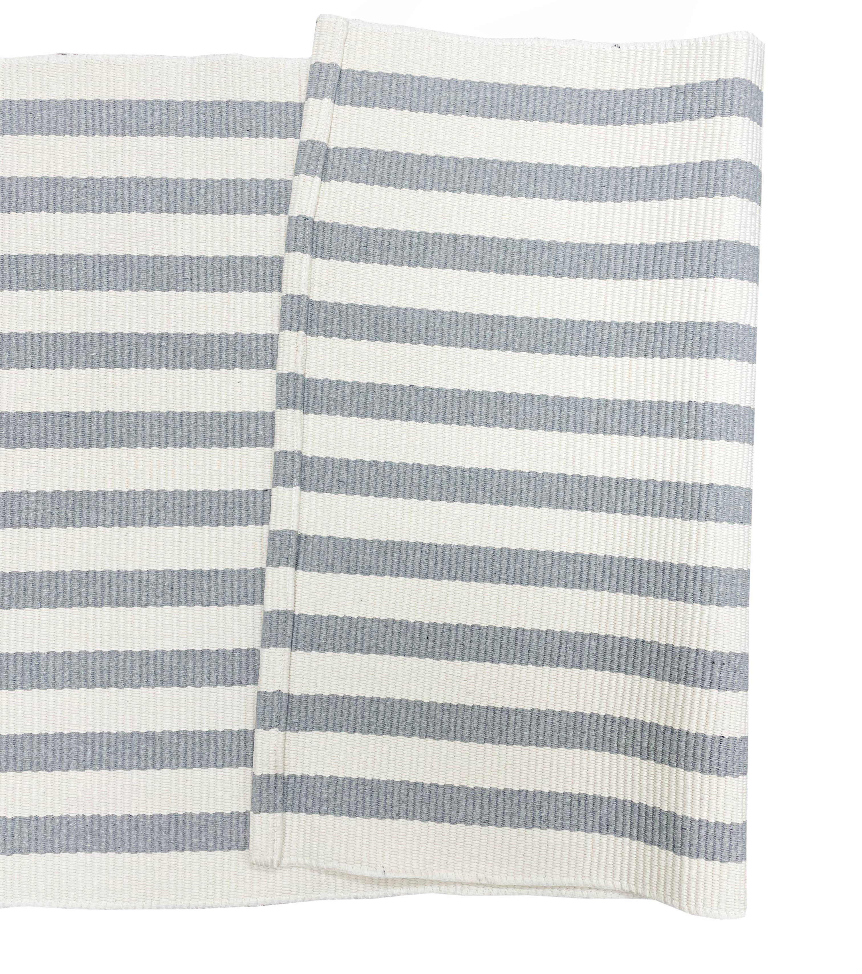 Striped fabric with alternating light blue and white stripes on a white background