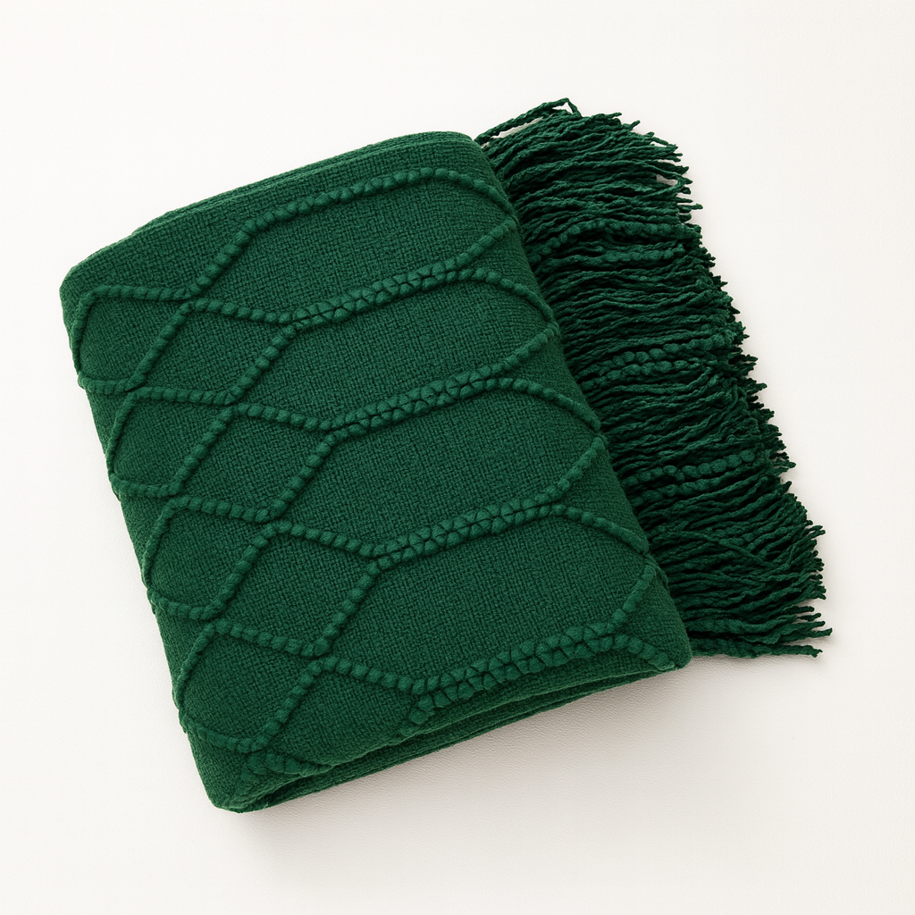 Green blanket with fringe on a white background