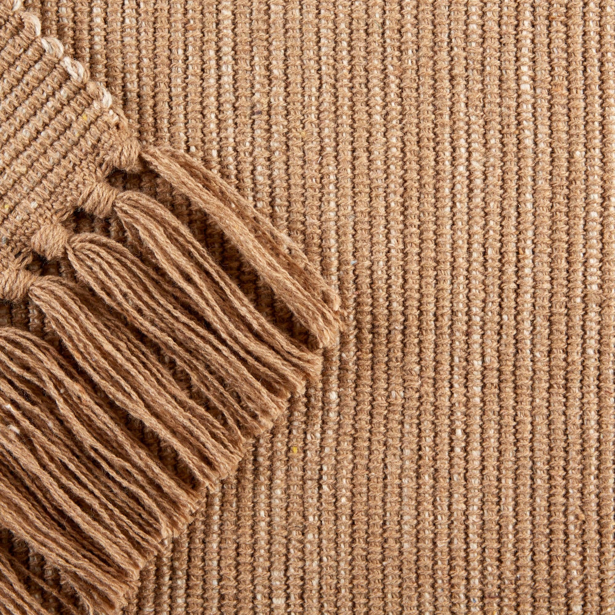 Close-up of a textured brown rug with fringes