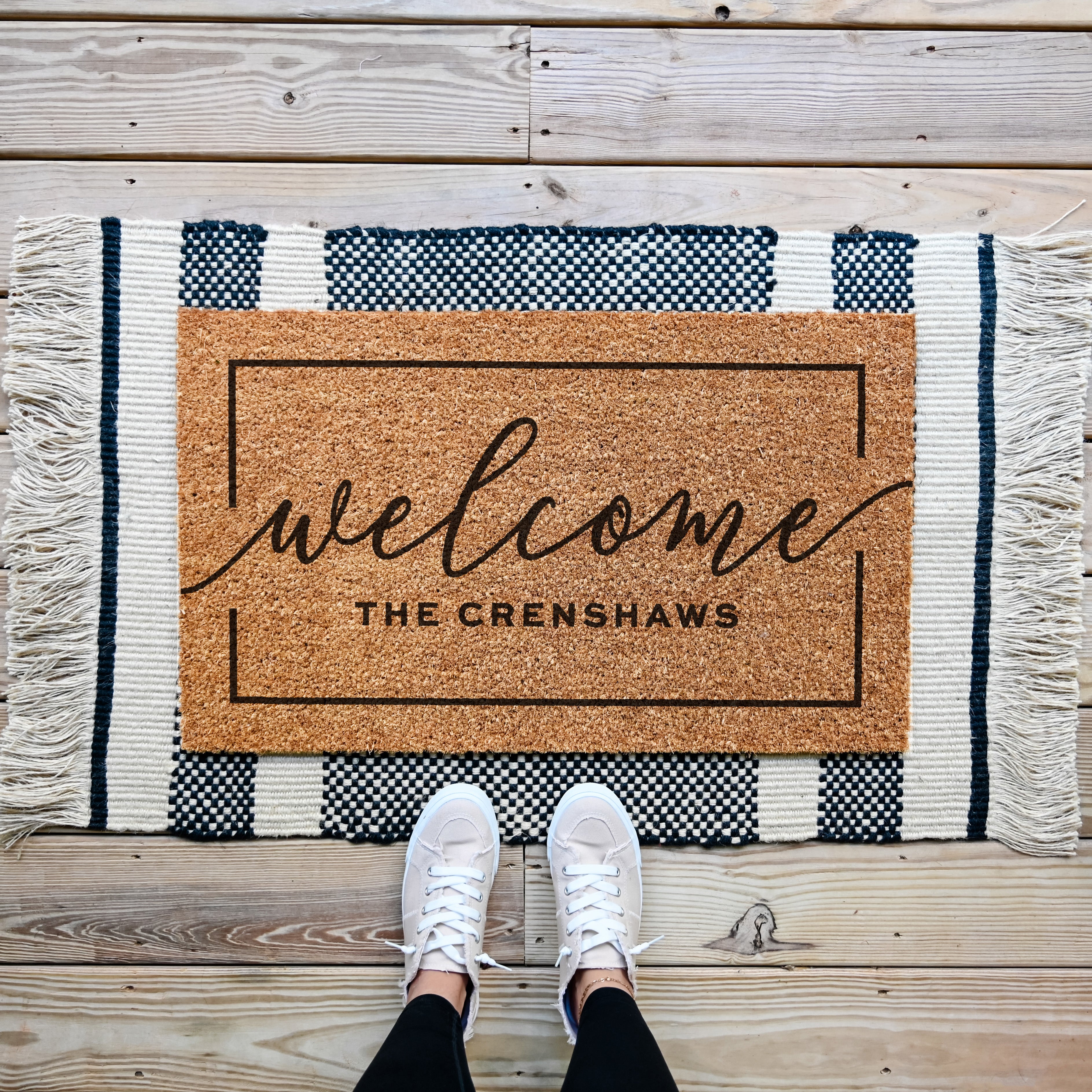 Custom Doormat that says welcome in the middle and is personalized underneath. There is a border that runs around the edge of the mat