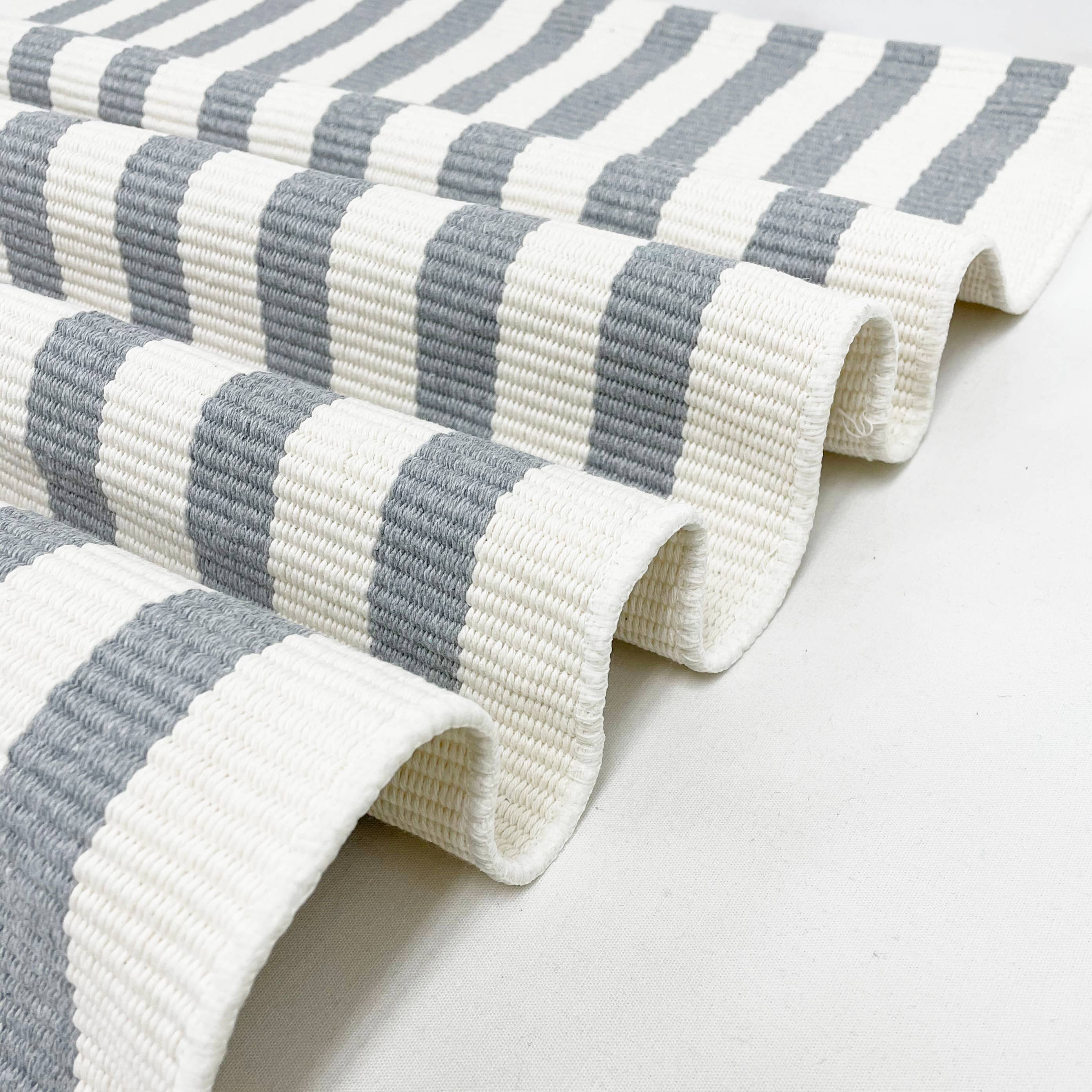 Gray and white striped rug on a light gray background